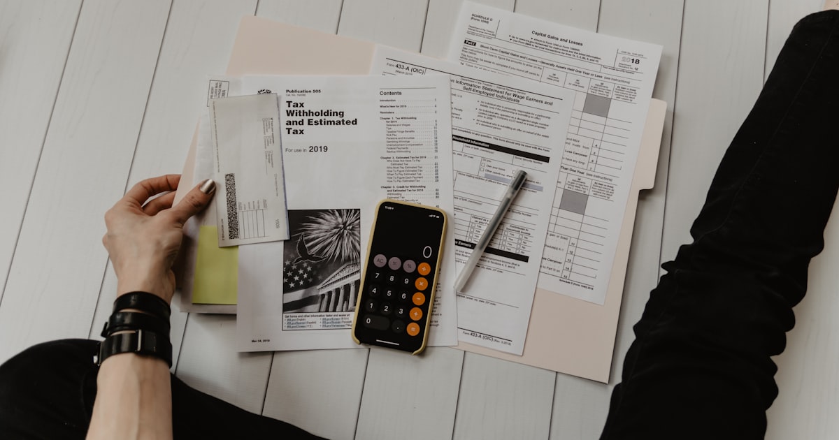 Tax forms and calculator spread out on a desk